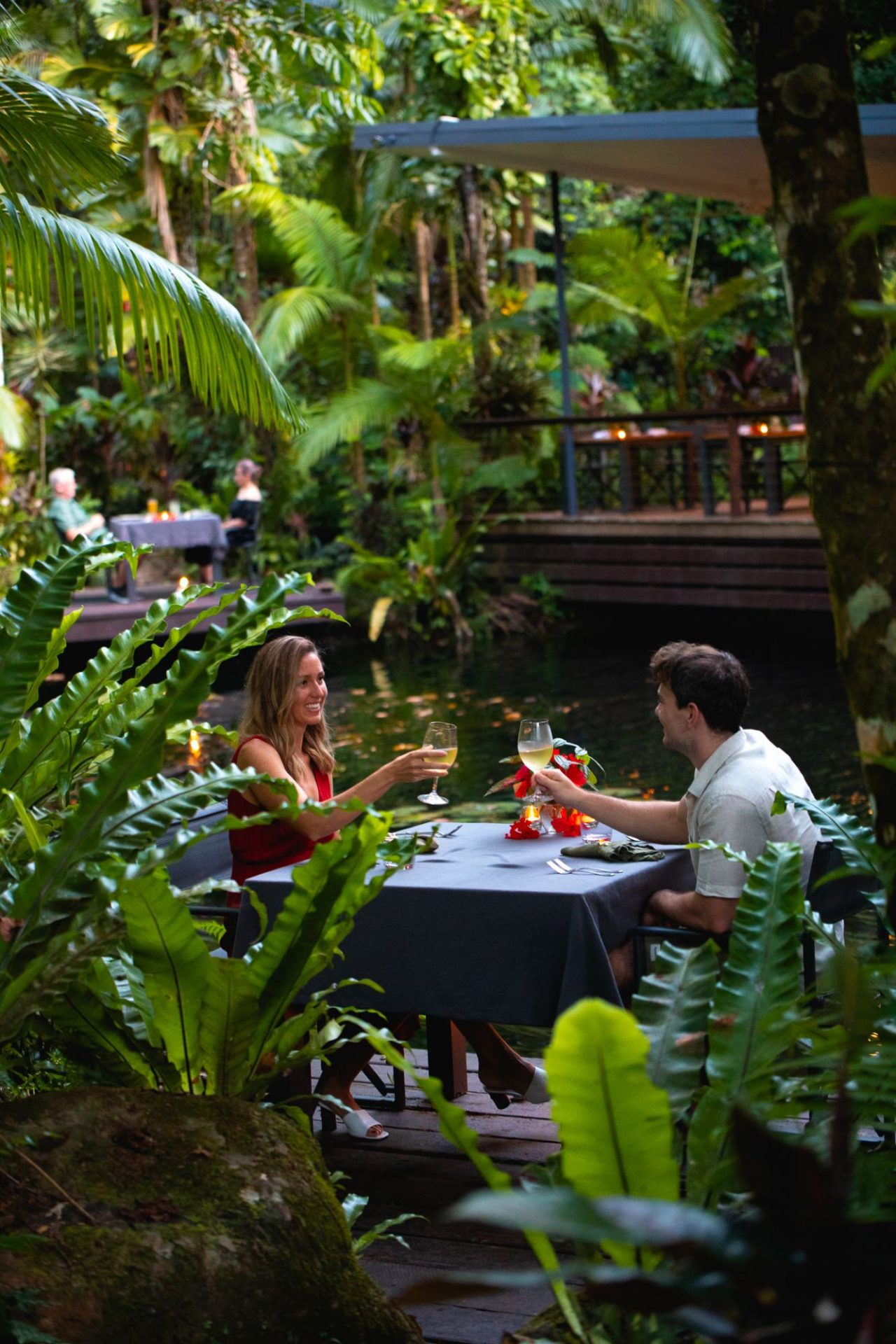 Couple dining lagoon-side at Julaymba Restaurant, Daintree Ecolodge